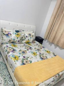 a bed with flowers on it in a room at NN Homestay @ Jasin Bestari in Kampong Bemban