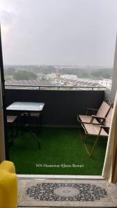 a balcony with a table and chairs and a view at NN Homestay @ Jasin Bestari in Kampong Bemban