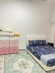 a bedroom with a bed and a dresser at NN Homestay @ Jasin Bestari in Kampong Bemban