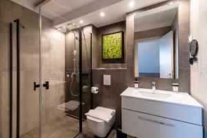 a bathroom with a toilet and a sink and a shower at Hotel Kőporos Hercegkút in Hercegkút