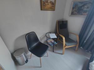 Habitación con 2 sillas y mesa. en Guest House Tullgatan 24, en Borgholm