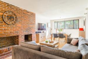 a living room with a couch and a brick wall at P&O Apartments Juhasów - Wawer in Warsaw