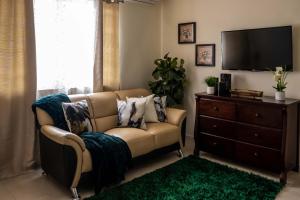 a living room with a couch and a tv at A Taste of Paradise - Vacation Rentals close to US Embassy & Restaurants in Nassau