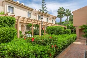 una casa con un jardín delante de ella en Los Amigos Beach Club, en La Cala de Mijas