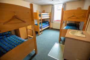 een kamer met 2 stapelbedden en een wastafel bij Inverness Youth Hostel in Inverness