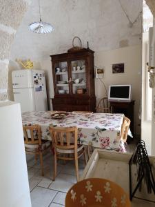 a kitchen with a table and a refrigerator at Trullo Galeotto in Martina Franca