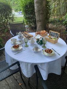 een witte tafel met borden voedsel erop bij Dar Aminya - Chambres d'hôtes in Marmande