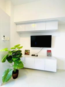 a living room with a tv on a white wall at Tagaytay Staycation in Tagaytay