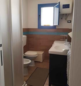 a bathroom with a toilet and a sink and a window at Holiday home in Portopalo 35405 in Portopalo