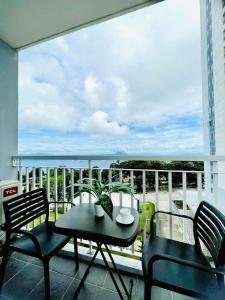 a balcony with a table and chairs and a view of the ocean at Tagaytay Staycation in Tagaytay