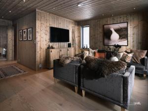ein Wohnzimmer mit 2 Sofas und einem Flachbild-TV in der Unterkunft Beautiful apartment - high standard - Geilo centre in Geilo