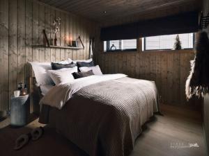 a bedroom with a bed with white sheets and a window at Beautiful apartment - high standard - Geilo centre in Geilo