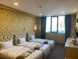 a hotel room with two beds and a window at Betlem Hotel -Tbilisi City in Tbilisi City