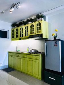 a kitchen with yellow cabinets and a refrigerator at Primavera Residence Silver 3Kates in Cagayan de Oro