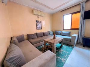 ein Wohnzimmer mit einem Sofa und einem Tisch in der Unterkunft Marrakech Mirage Home in Marrakesch