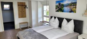 Un dormitorio con una cama con almohadas blancas y una ventana en MoselVilla No 7 en Pommern