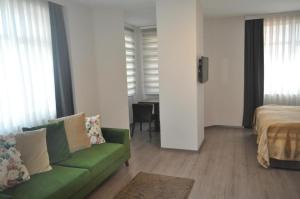 uma sala de estar com um sofá verde e uma cama em Hotel Atabay em Istambul