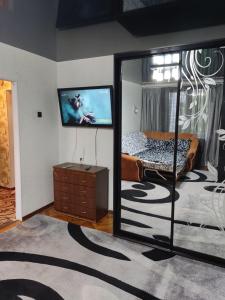 a bedroom with a mirror and a bed and a tv at Стильная квартира in Tiraspol