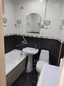 a bathroom with a sink and a toilet and a bath tub at Стильная квартира in Tiraspol