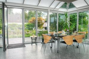 a dining room with a table and chairs and windows at Waldparadies in Neftenbach I Winterthur Nummer 1 in Neftenbach