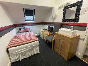 Dormitorio pequeño con cama y lavamanos en Manhattan Hotel, en Blackpool