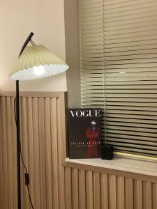 eine Lampe auf einem Fensterbrett neben einem Vogue-Schild in der Unterkunft Nhật Quang House in Đà Nẵng