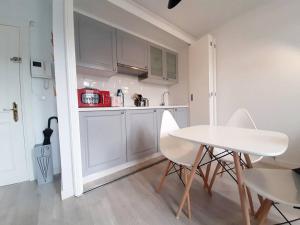 a kitchen with white cabinets and a white table and chairs at P Sanz 1, 405 by YBH in Vigo +12 photos