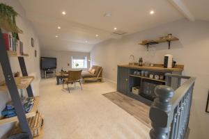 ein Wohnzimmer mit einem Sofa, einem Tisch und einem TV in der Unterkunft Penny Pot Cottage in Middleham