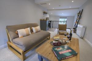 ein Wohnzimmer mit einem Sofa und einem Tisch in der Unterkunft Penny Pot Cottage in Middleham