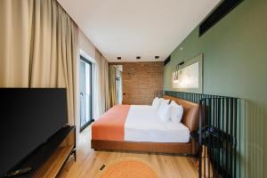a bedroom with a bed and a flat screen tv at Hotel 21 in Tbilisi City