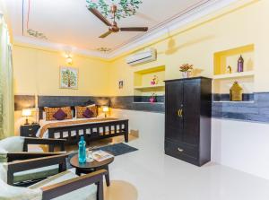 Kalyan Villa Homestay في أودايبور: غرفة معيشة مع سرير وأريكة