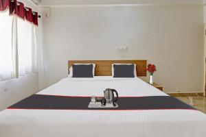 - une chambre avec un grand lit et une couverture rouge blanche et bleue dans l'établissement Flagship Sri Sai Comforts, à Bangalore