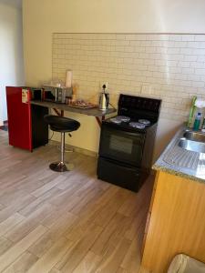 a kitchen with a stove and a counter with a stool at The Oasis Accommodation in Lüderitz