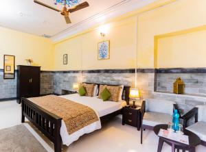 1 dormitorio con 1 cama y 1 silla en Kalyan Villa Homestay, en Udaipur