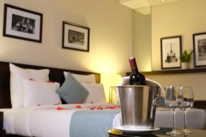 - une bouteille de vin dans un seau à côté d'un lit dans l'établissement The Parisian Hotel, à Beyrouth