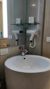 فندق ريزدنسي فورت في مومباي: حمام مع حوض أبيض ومرآة