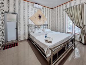 um quarto com uma cama com uma garrafa de água em Homestay Sakinah Syariah Mitra RedDoorz em Bukittinggi