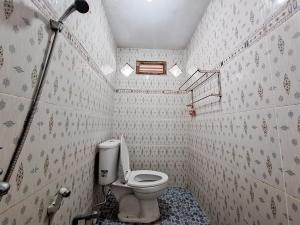 y baño pequeño con aseo y ducha. en Homestay Sakinah Syariah Mitra RedDoorz en Bukittinggi