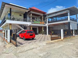 a red car parked in front of a house at Homestay Sakinah Syariah Mitra RedDoorz in Bukittinggi