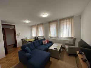 a living room with a blue couch and a table at Villa Bastion in Sarajevo
