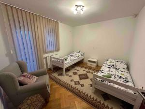 ein kleines Zimmer mit 2 Betten und einem Stuhl in der Unterkunft Villa Bastion in Sarajevo