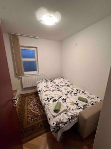 ein kleines Schlafzimmer mit einem Bett und einem Fenster in der Unterkunft Villa Bastion in Sarajevo