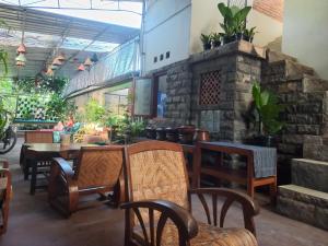 een restaurant met een tafel, stoelen en planten bij ADA Homestay in Borobudur