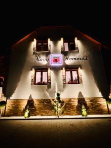 a building with a sign on the front of it at Nagy-Homoród Étterem és Panzió in Rareş