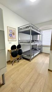 2 Stühle in einem Zimmer mit Etagenbett in der Unterkunft Apartment mit 3 Betten, Küche & Bad in Kassel in Kassel