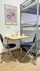 einen Schreibtisch mit 2 Stühlen und einem Etagenbett in der Unterkunft Apartment mit 3 Betten, Küche & Bad in Kassel in Kassel