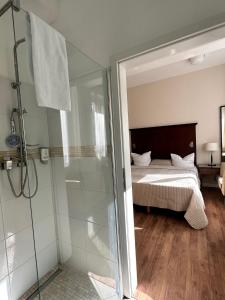a bathroom with a shower and a bed at Park Apart Hotel Gatower Str. in Berlin