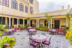 a patio with tables and chairs in a courtyard at Kalyan Villa Homestay in Udaipur