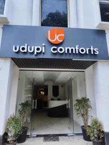 a sign for a uapp contracts office in front of a building at Udupi Comforts in Udupi