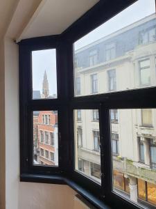 a window with a view of a city at Den Gulden Hoorn in Antwerp